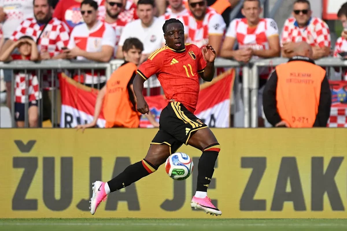 Player in red jersey running with soccer ball