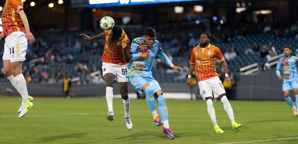 Players competing for the ball in USL match