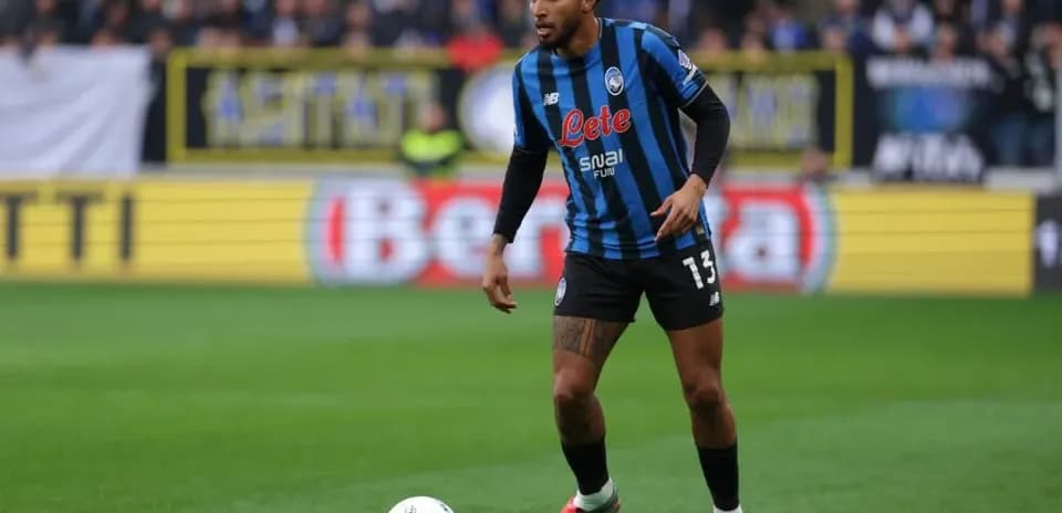 Player in Atalanta kit controlling ball on field