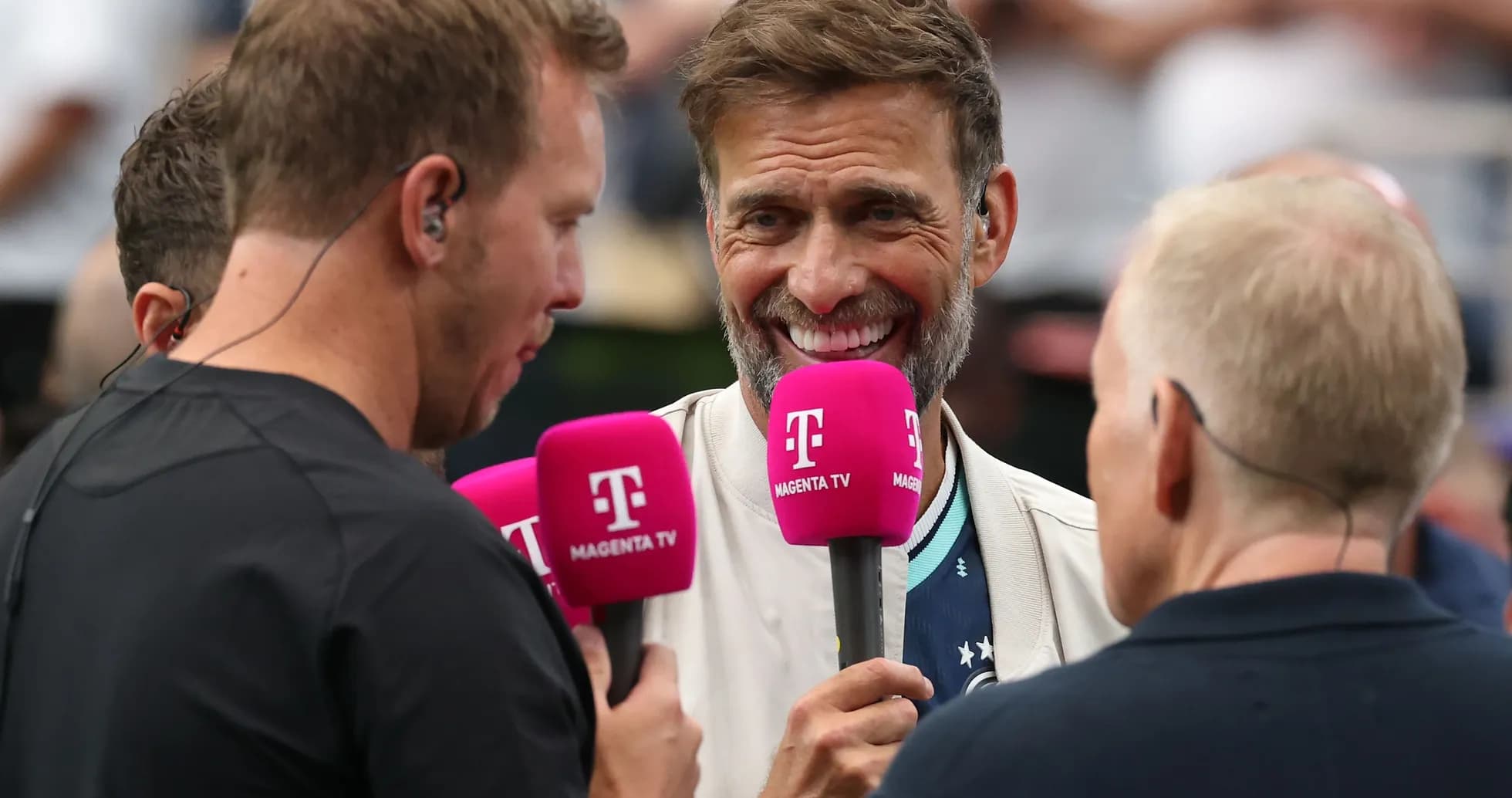 Four presenters holding microphones during a broadcast