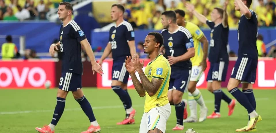 Brazilian player kneeling while Scottish players celebrate