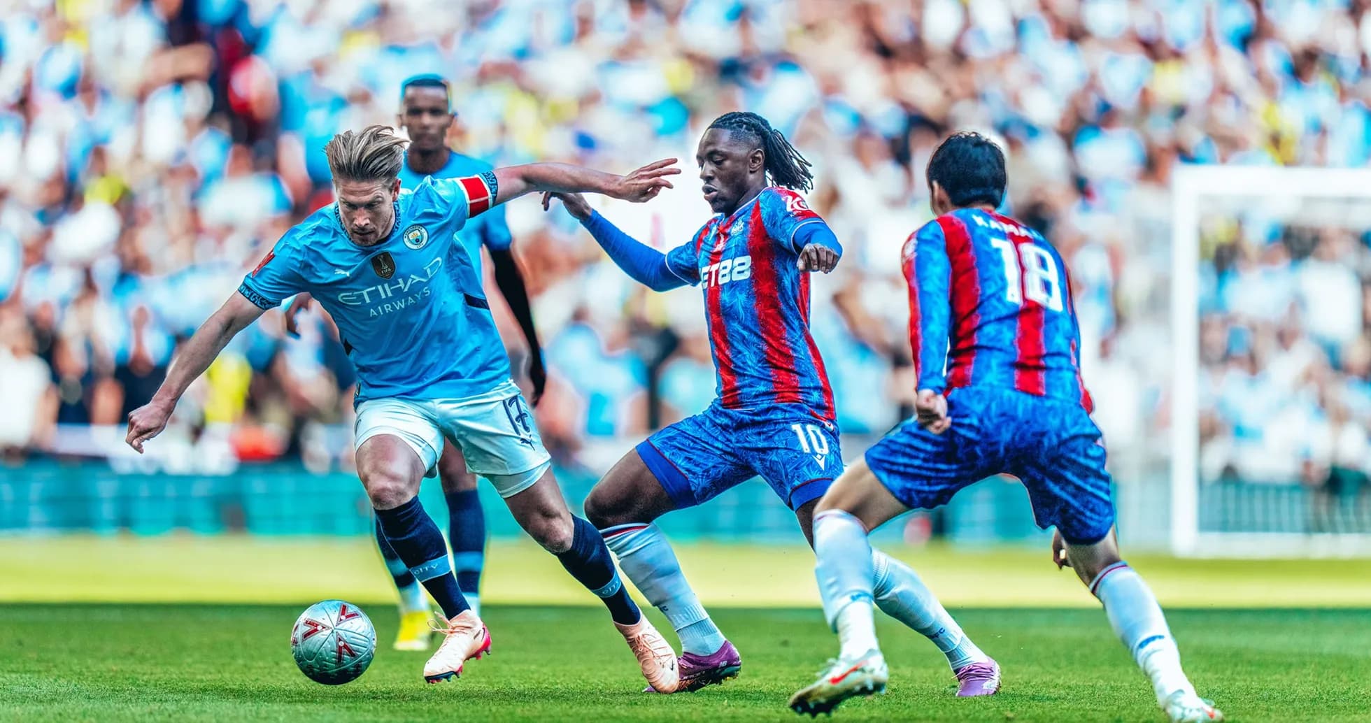 Manchester City player challenging Crystal Palace opponent