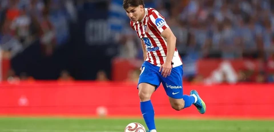 Player in Atlético Madrid kit dribbling the ball
