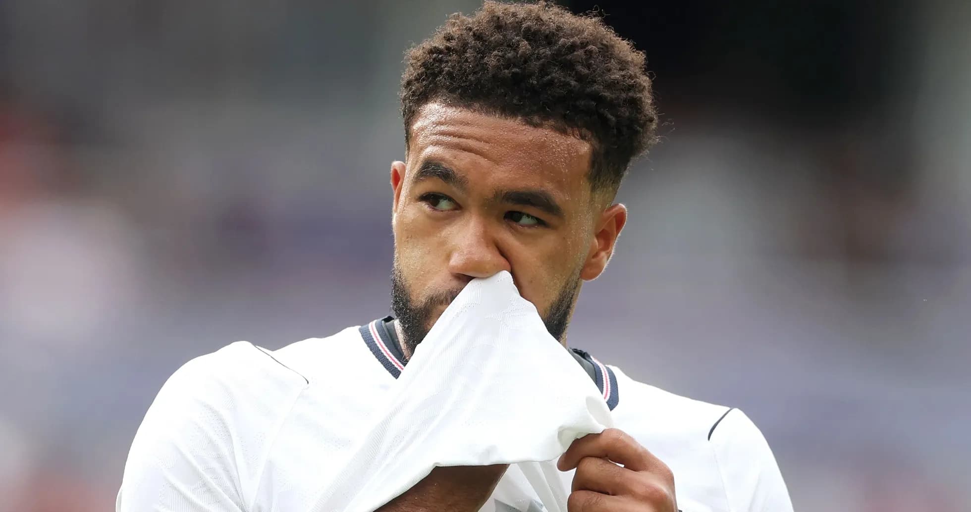 Player wiping his face with jersey during match