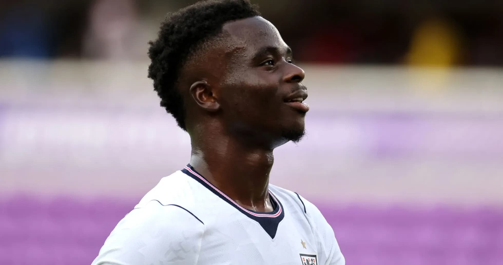 Player in England jersey smiling during match
