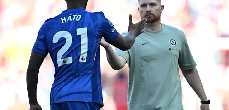 Player Hato greeting coach during match substitution