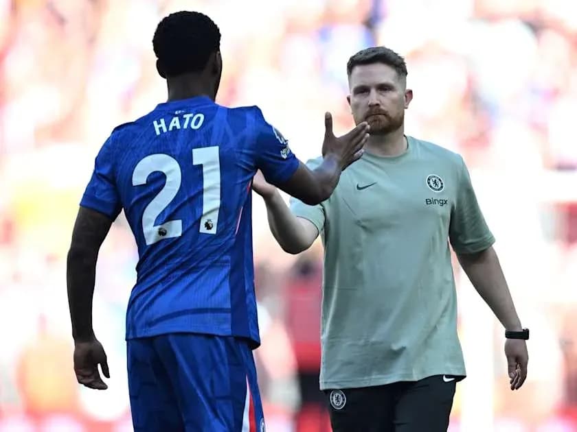 Player Hato greeting coach during match substitution
