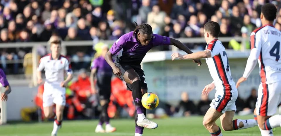 Fiorentina player dribbling against Genoa defense