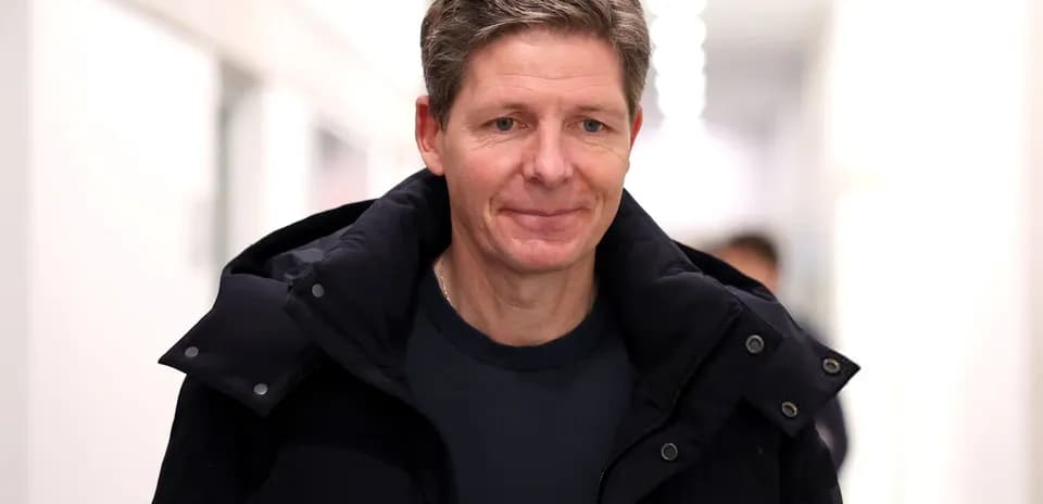 Person walking in a hallway wearing a black jacket