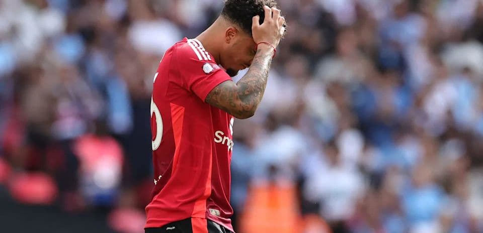 Player in red jersey looking dejected on field