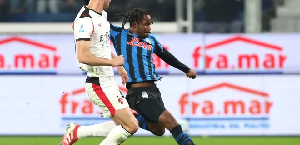 AC Milan player tackling Atalanta opponent