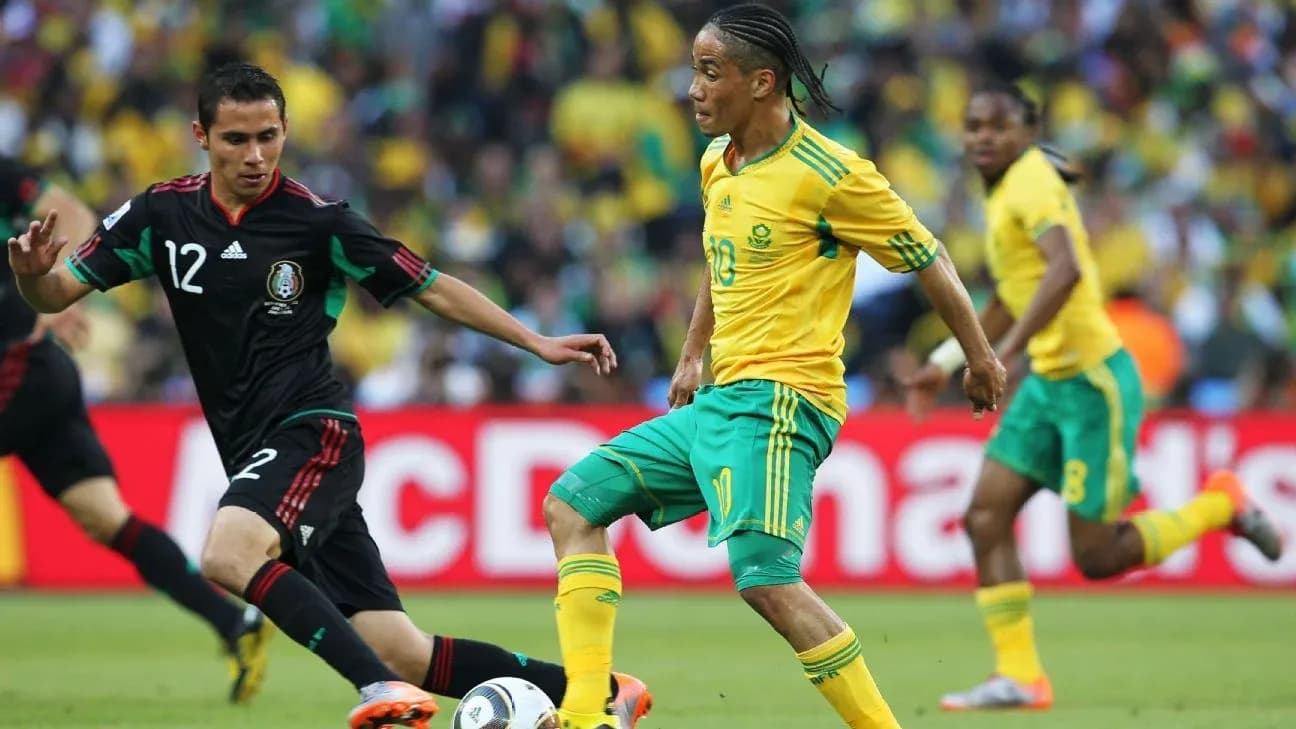 South African player dribbling past Mexican defender