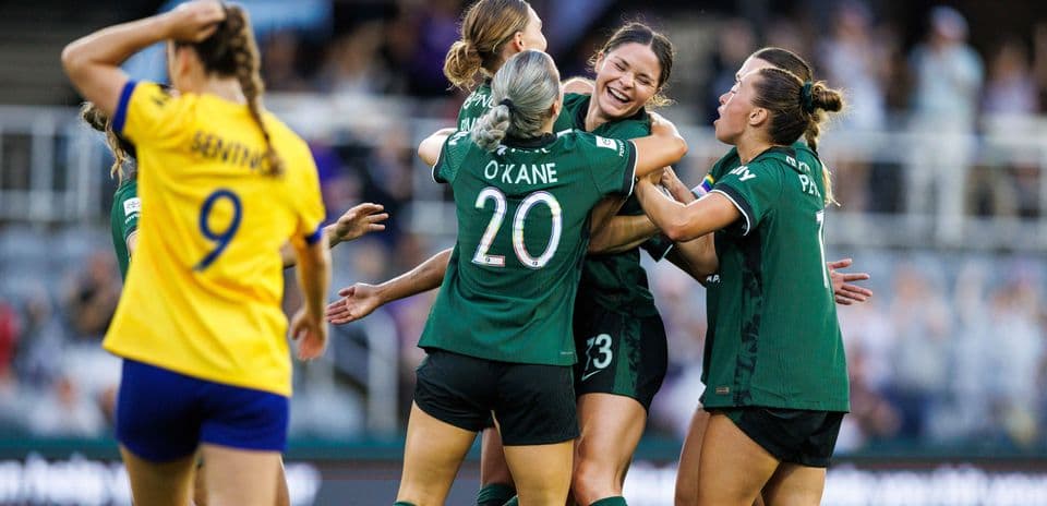 Players celebrating a goal during NWSL match