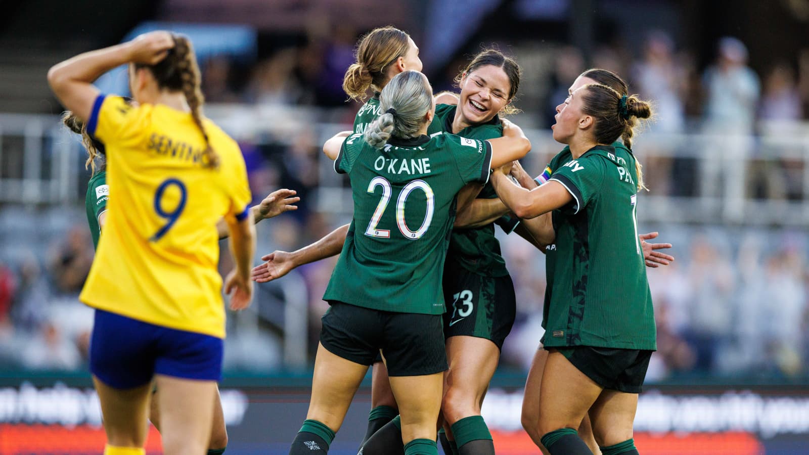 Players celebrating a goal during NWSL match
