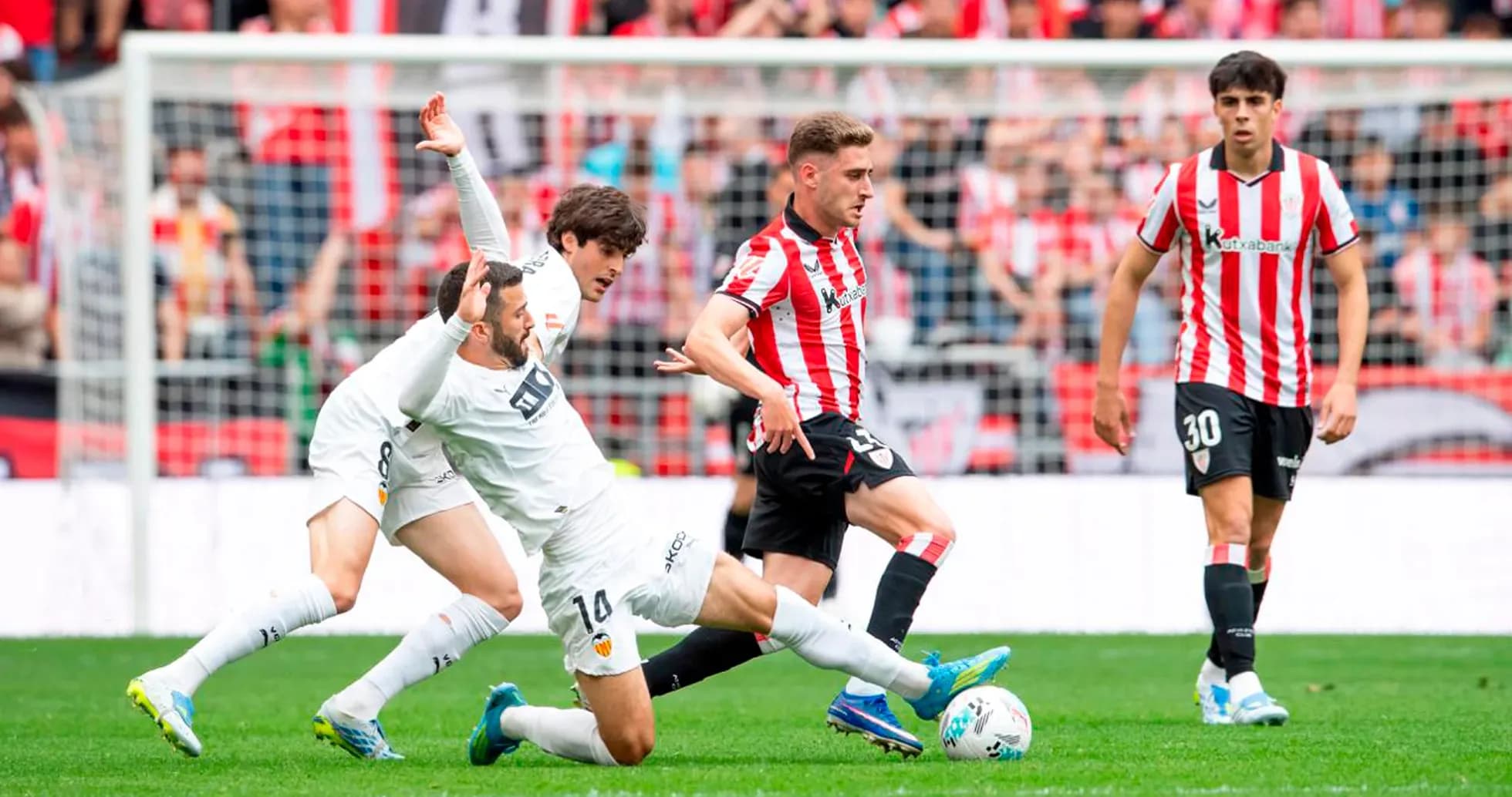 Athletic Club player dribbling past Valencia defenders