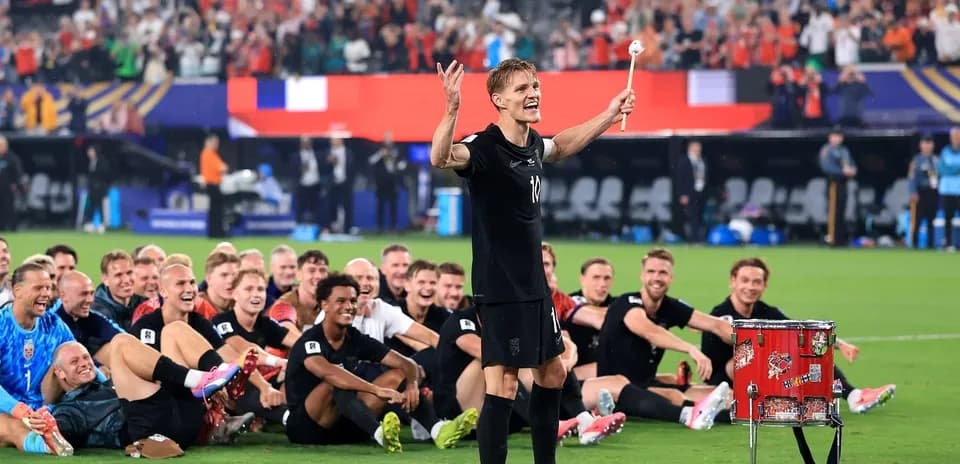 Players celebrating with a drum after the match