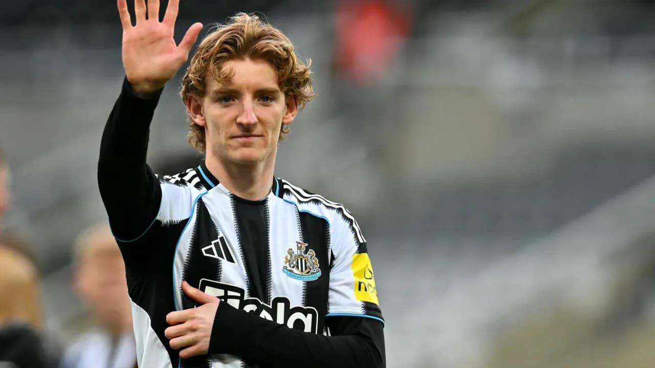 Player waving while wearing Newcastle United jersey
