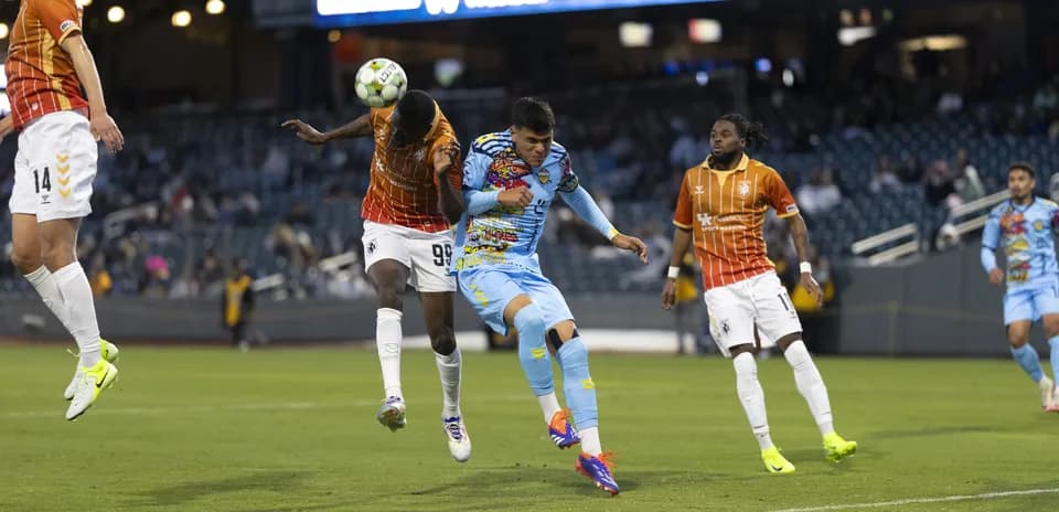 Players competing for the ball in USL match