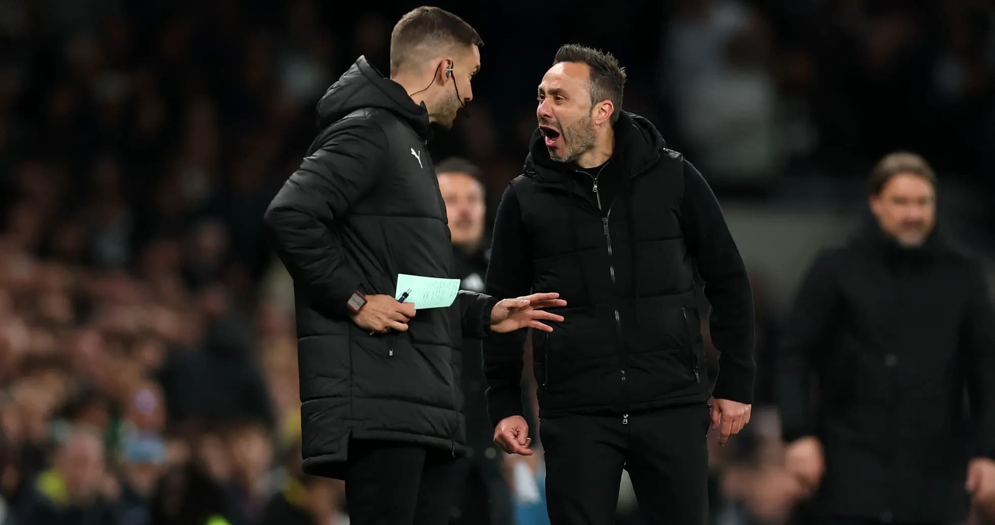 Two coaches discussing strategies during a match