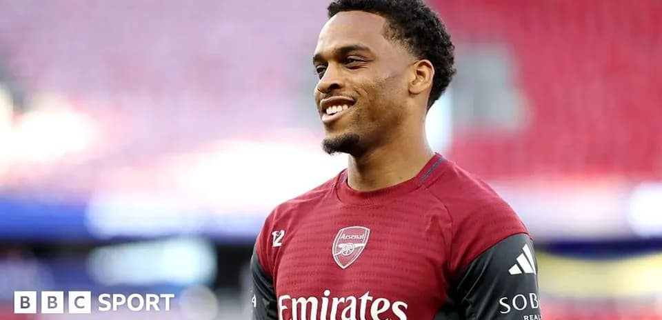 Player in Arsenal training kit smiling on pitch