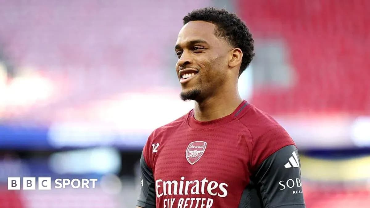 Player in Arsenal training kit smiling on pitch