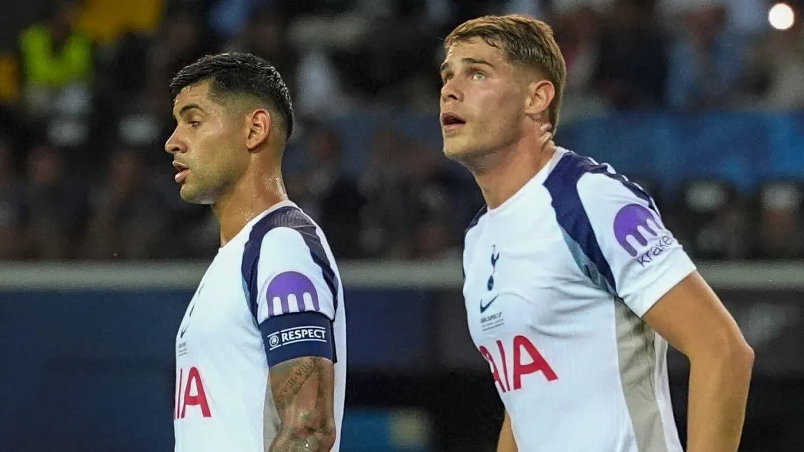 Two Tottenham players observing the game in uniform Two Tottenham players observing the game in uniform