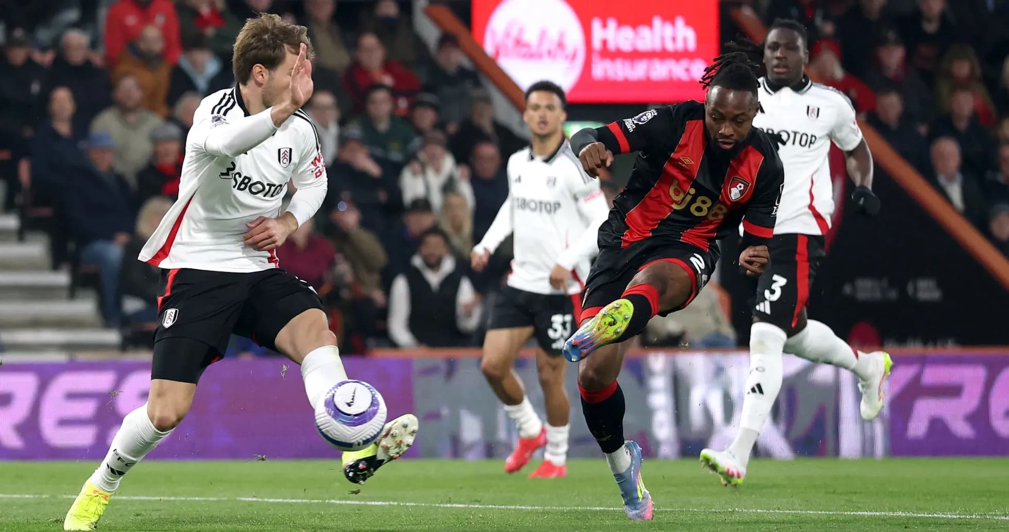 Fulham player challenging Bournemouth opponent for the ball Fulham player challenging Bournemouth opponent for the ball