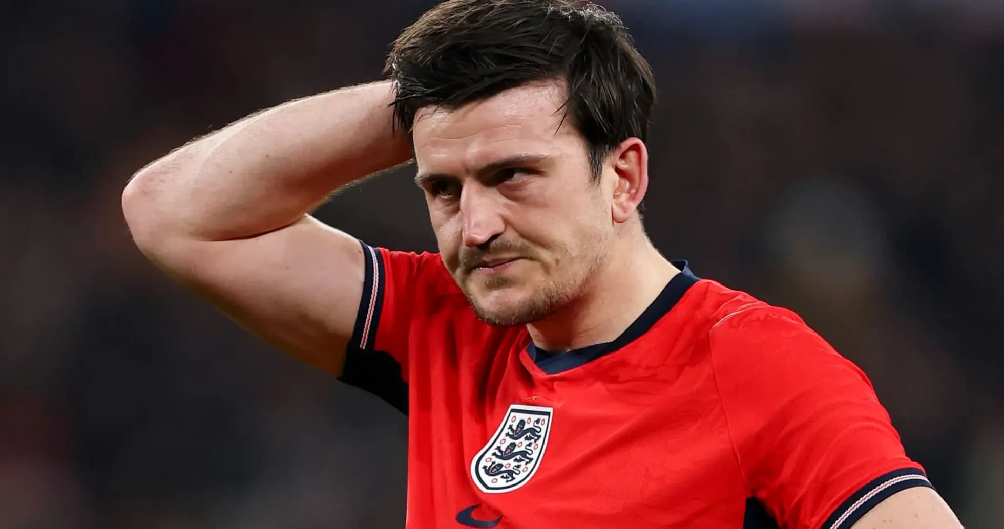 Player in red England jersey looks concerned on field Player in red England jersey looks concerned on field