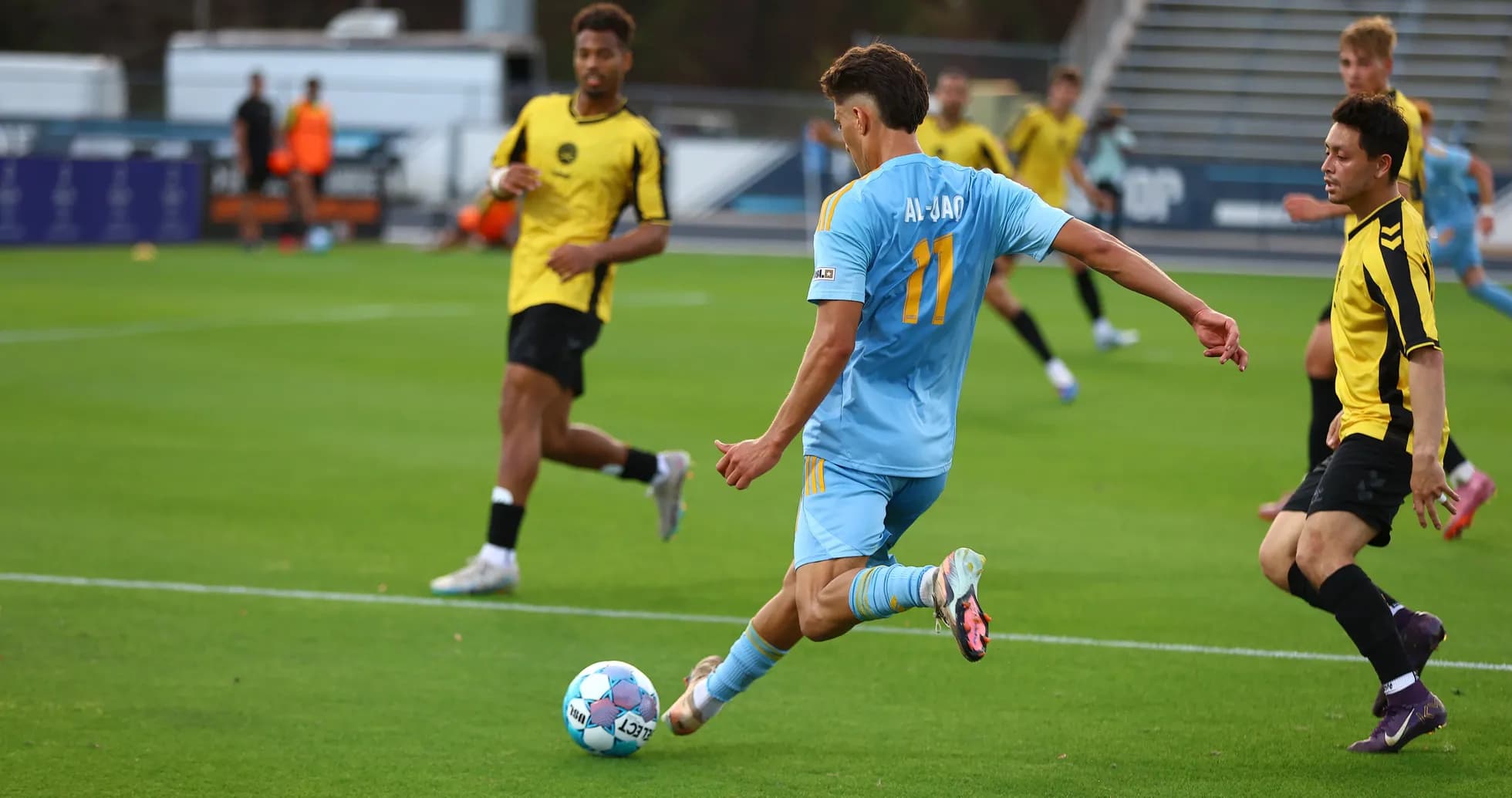 Player in light blue jersey kicking football Player in light blue jersey kicking football