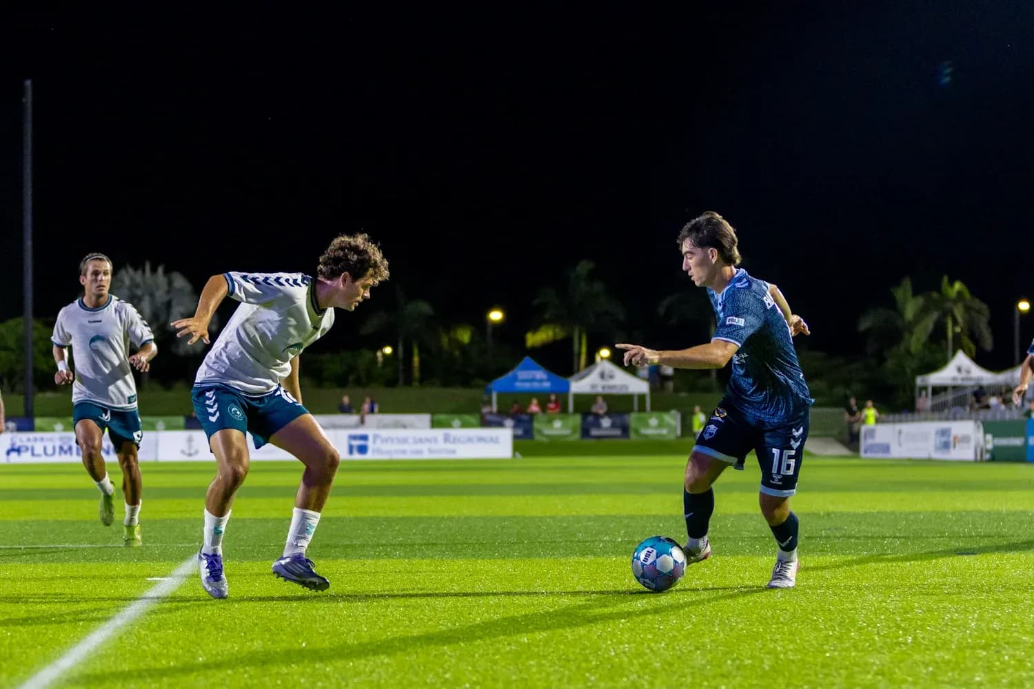 Two players competing for the ball in football Two players competing for the ball in football