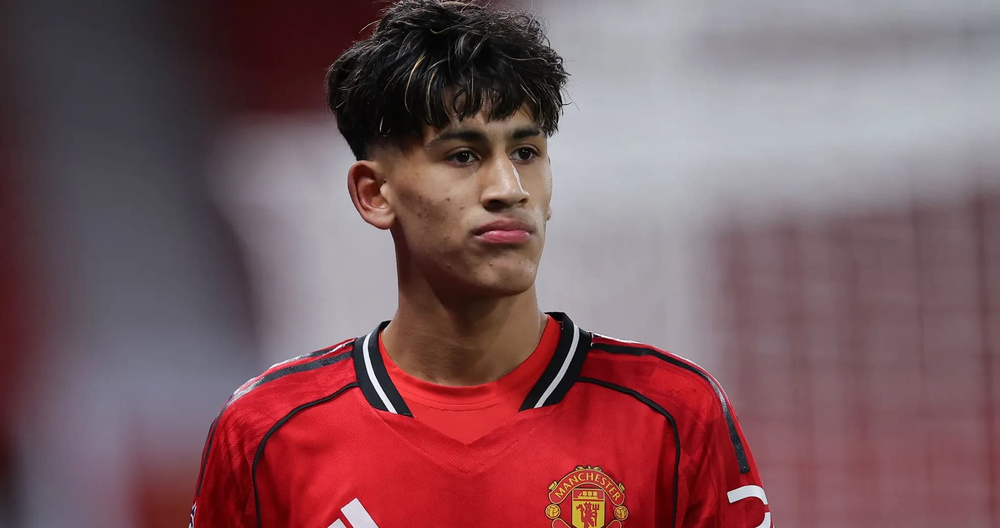 Young player in Manchester United jersey on field Young player in Manchester United jersey on field
