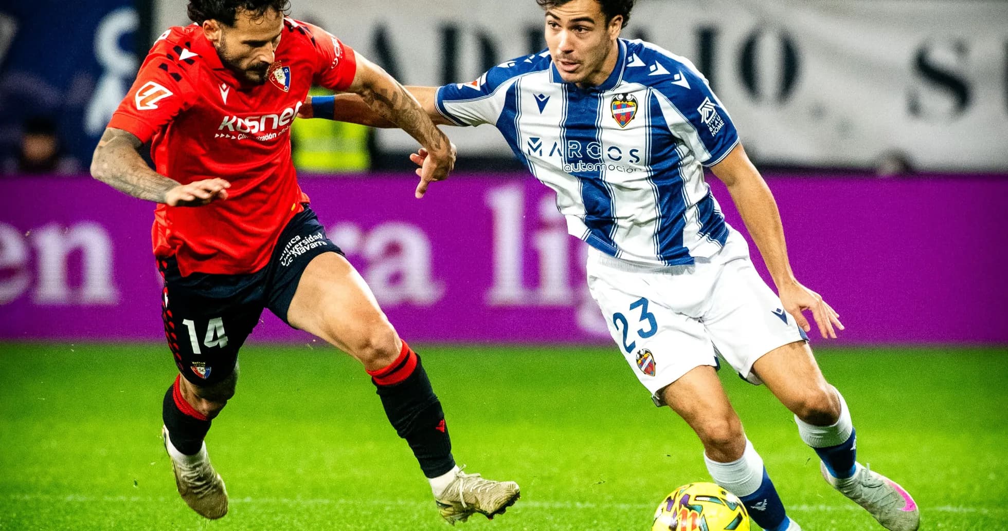 Levante player dribbling past Osasuna defender Levante player dribbling past Osasuna defender