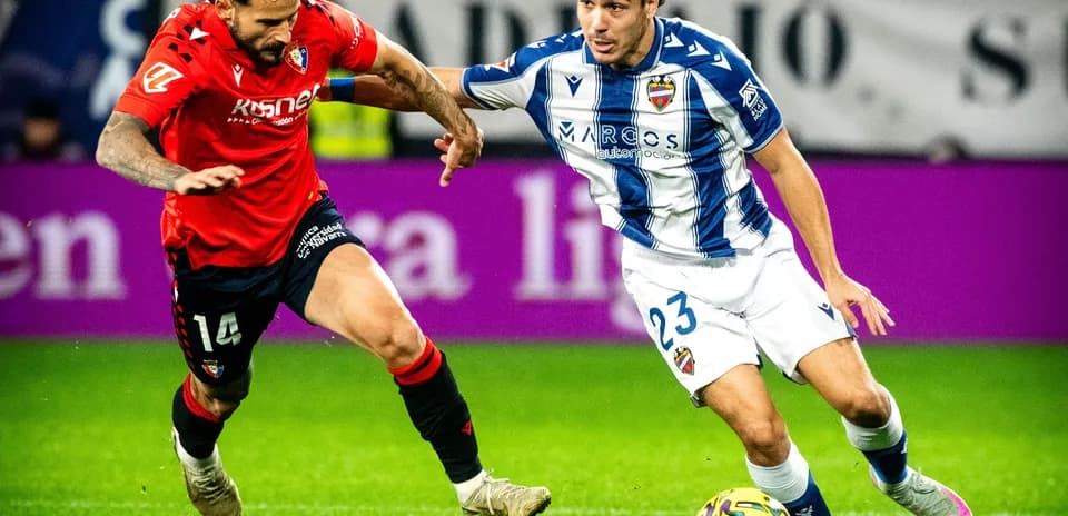Levante player dribbling past Osasuna defender Levante player dribbling past Osasuna defender