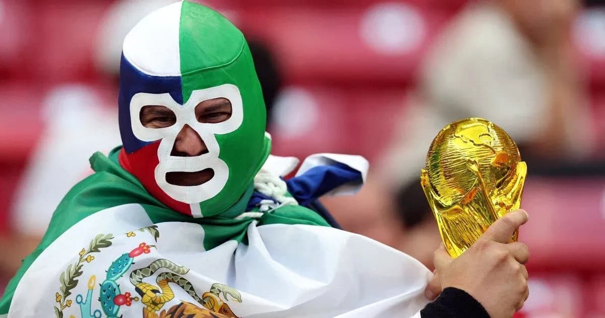 Fan in mask holding FIFA World Cup trophy Fan in mask holding FIFA World Cup trophy