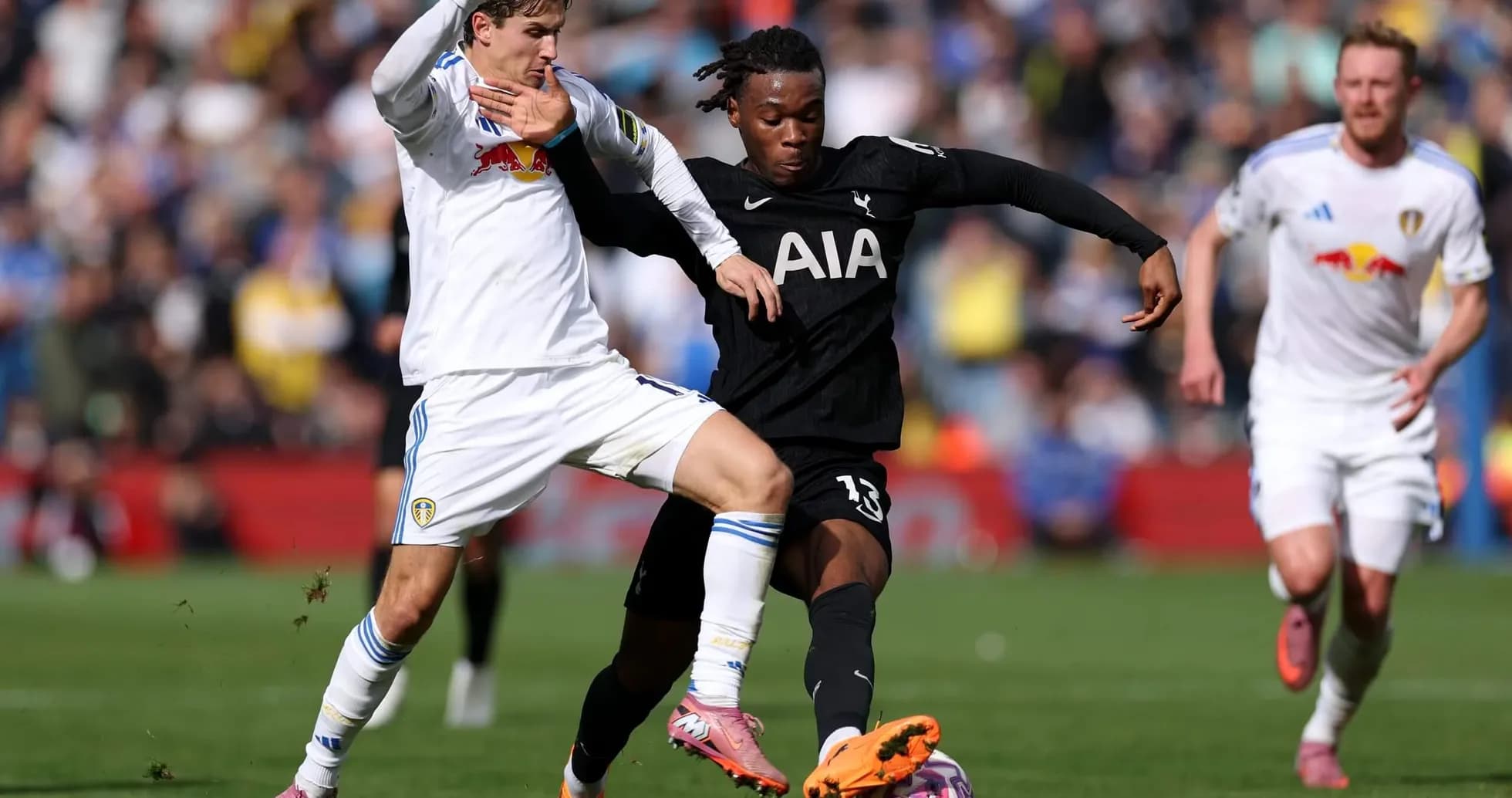 Tottenham player tackling Leeds opponent during match Tottenham player tackling Leeds opponent during match