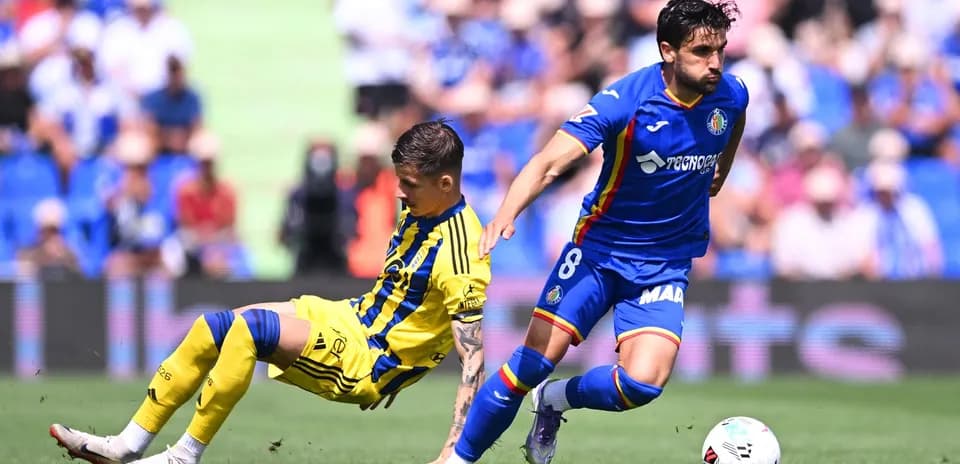 Oviedo player tackled by Getafe opponent during match Oviedo player tackled by Getafe opponent during match